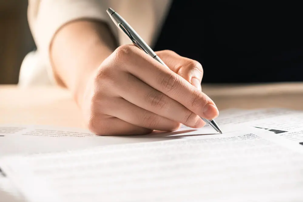 mão assinando documento
