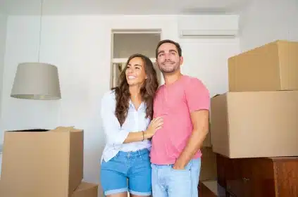 mudar-de-casa-casal-entrando-na-nova-casa-com-caixas-fechadas-e-empilhadas-atras
