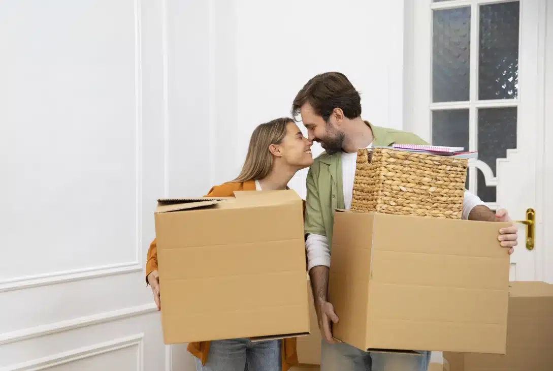 mudar-de-casa-casal-hetero-jovem-entrando-na-casa-nova-com-caixas-nas-maos