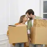 mudar-de-casa-casal-hetero-jovem-entrando-na-casa-nova-com-caixas-nas-maos