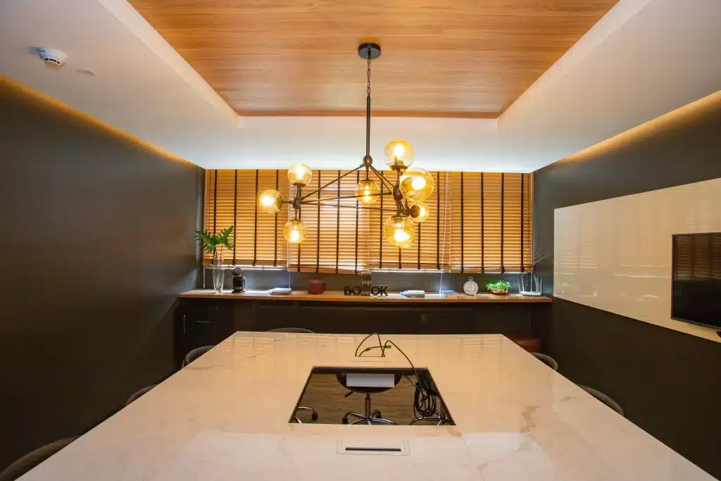 valorizacao-de-imoveis-sala-de-reuniao-do-condominio-plex-no-una-com-mesa-grande-no-centro-da-sala-e-bancada-com-objetos-na-parede