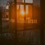 : Fachada de uma empresa de tecnologia no Parque Unamakers com a luz do sol refletindo na janela.