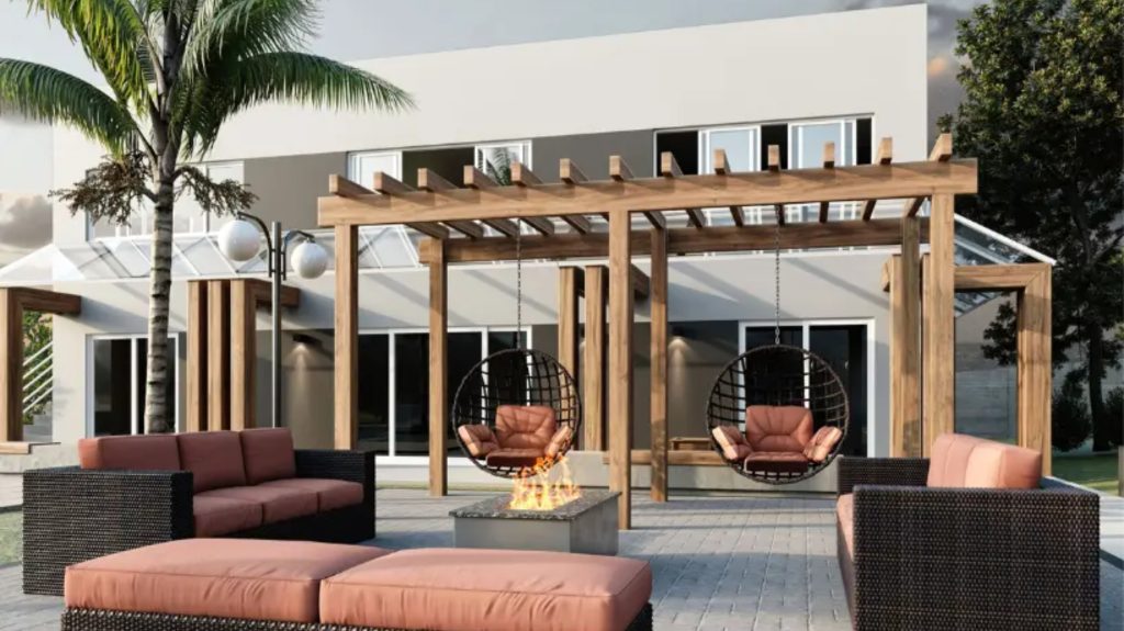 Área externa com pergolado de madeira, poltronas suspensas, sofás e lareira ao ar livre.